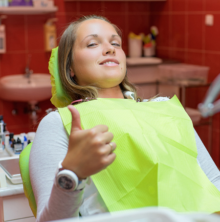 girl giving thumbs up after dental emergency